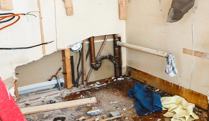 Damaged wall exposing leaked water pipe Damaged wall exposing leaked water pipe