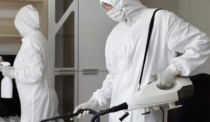 Two workers spraying in the biohazard area