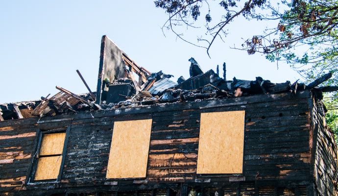 Boarded-up home after fire House affected by fire with windows covered with boards