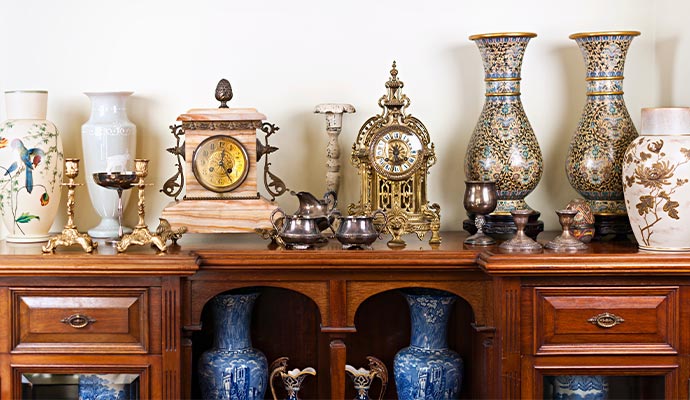 Collection of clean antique items on wooden cabinet Collection of clean and polished antique items displayed neatly on a wooden cabinet
