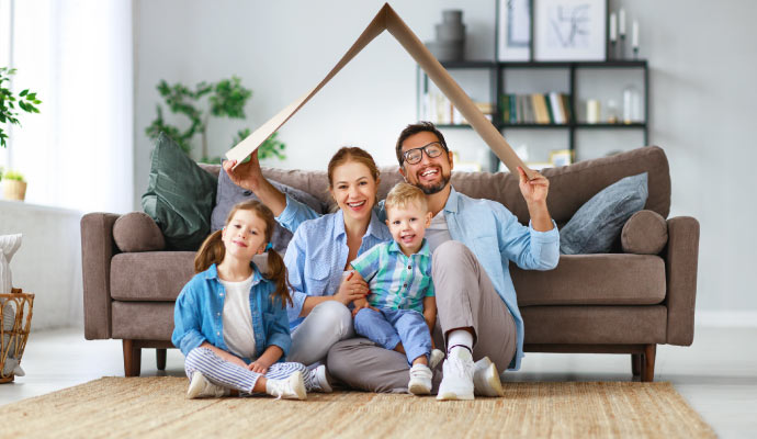 A happy family sitting on the floor in a clean room