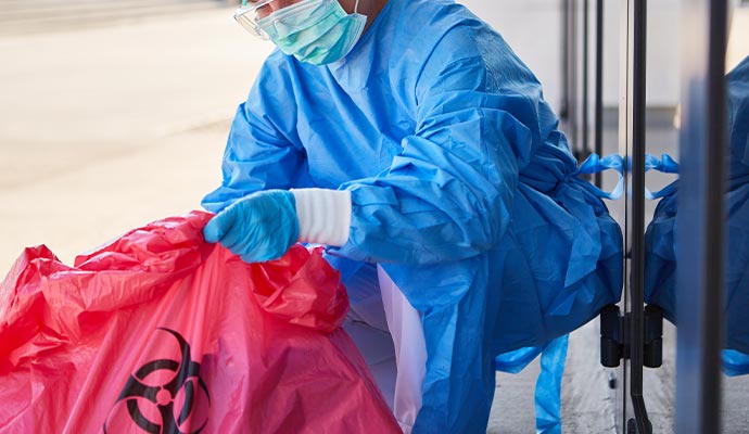 Professional worker cleaning biohazard waste