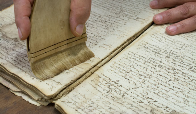 Person cleaning manuscript with equipment