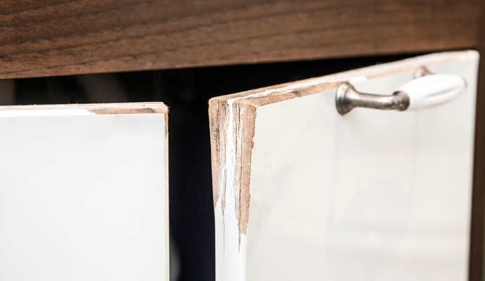 A damaged cabinet door with chipped