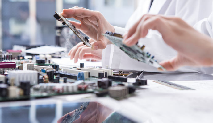 Person working with electronic circuit boards in a lab