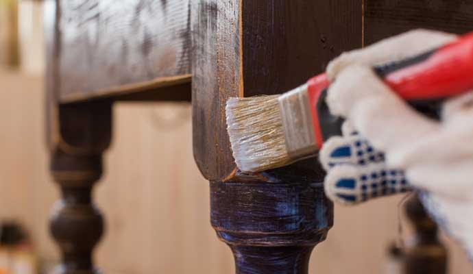 A person cleaning furniture with equipment