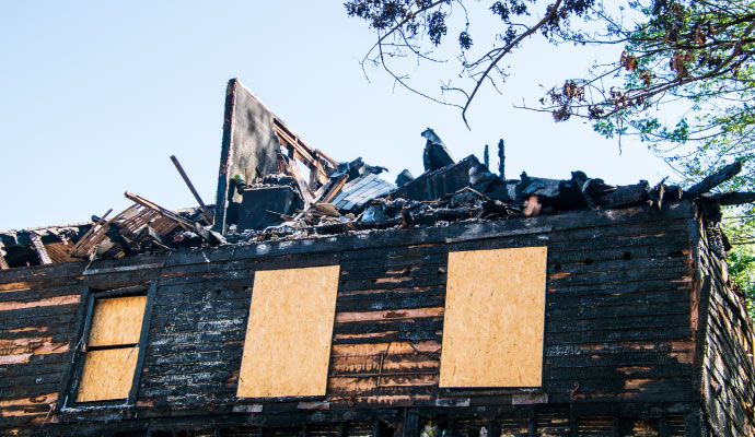 Boarded up fire damaged house