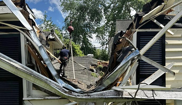 a house with significant roof damage caused by natural disaster