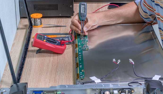 A person is repairing electronic circuit board