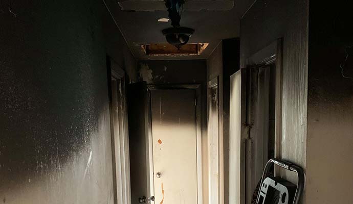 Fire damaged home with soot on walls Walls and ceiling covered with black soot and smoke stains after a house fire.