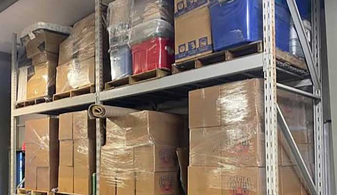 A storage area with metal shelving units holding various cardboard boxes