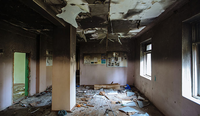 Burned room with damaged ceiling and wall