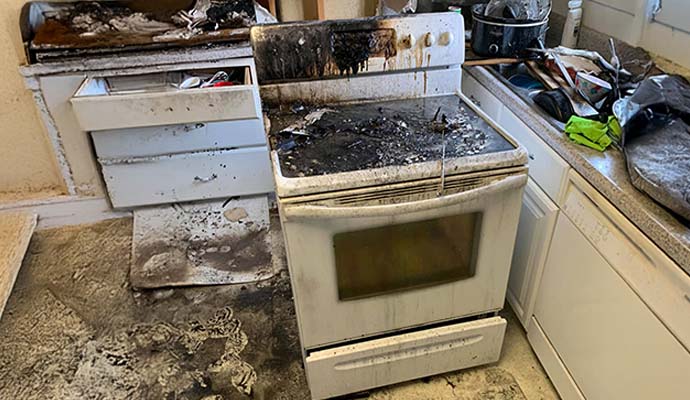 Fire-damaged washing machine with burn marks Fire-damaged washing machine showing visible burn marks and surface discoloration