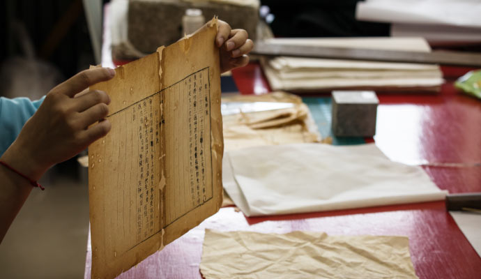 An expert holding a damaged document An expert holding a damaged paper document for restoration