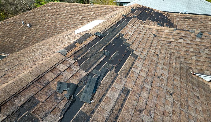 Gutter filled with granules and cracked shingles