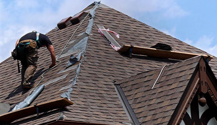 Professional worker restoring damaged roof