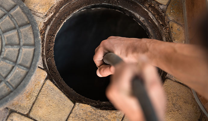 Professional worker cleaning sewage water